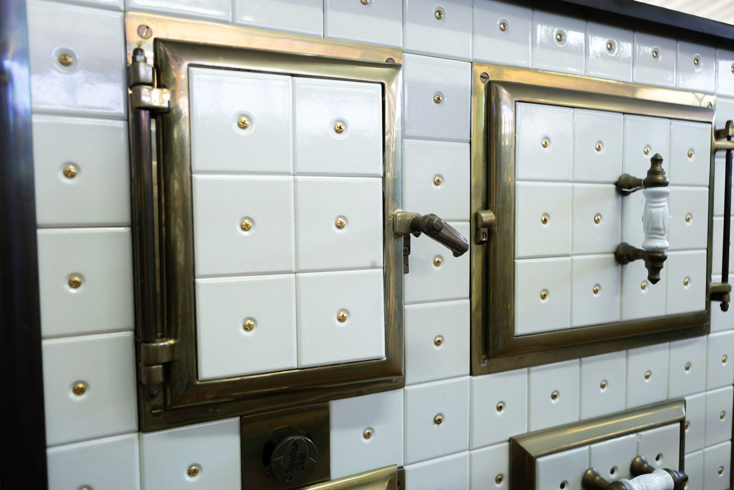 cucina con piastrelle bianche e inserti ottone