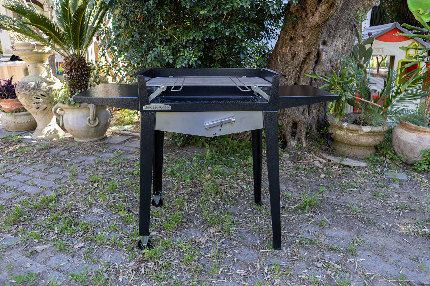 barbecue con carrello e ruote in giardino
